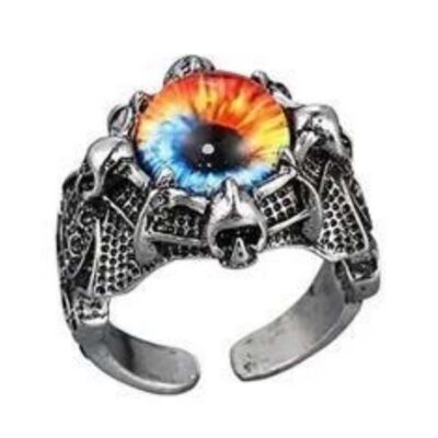 Close-up of a silver-plated ring with a vibrant, multi-colored dragon eye at the center, surrounded by skull and claw details.