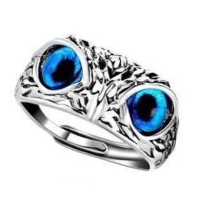 Close-up of an adjustable silver-plated ring featuring two vivid blue "owl" or "eagle" eyes and a textured band.